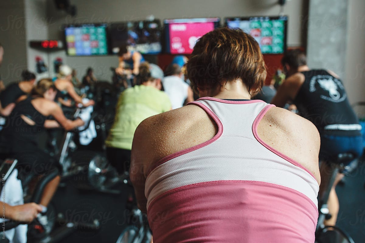 Sweaty back, neack and shoulders of caucasian woman working out at spin class