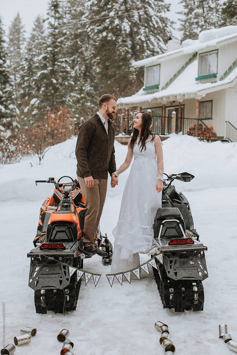 Wedding Couple Posed with Snowmobiles at Winter Wedding
