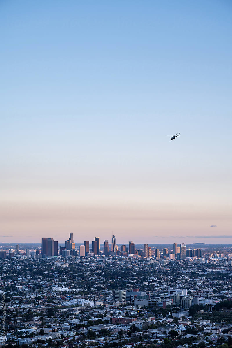 A helicopter flying over Los Angeles at sunset