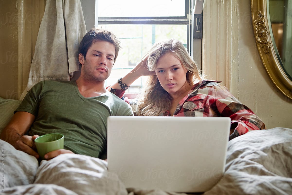 Couple in Bed Using Laptop for Wifi Entertainment