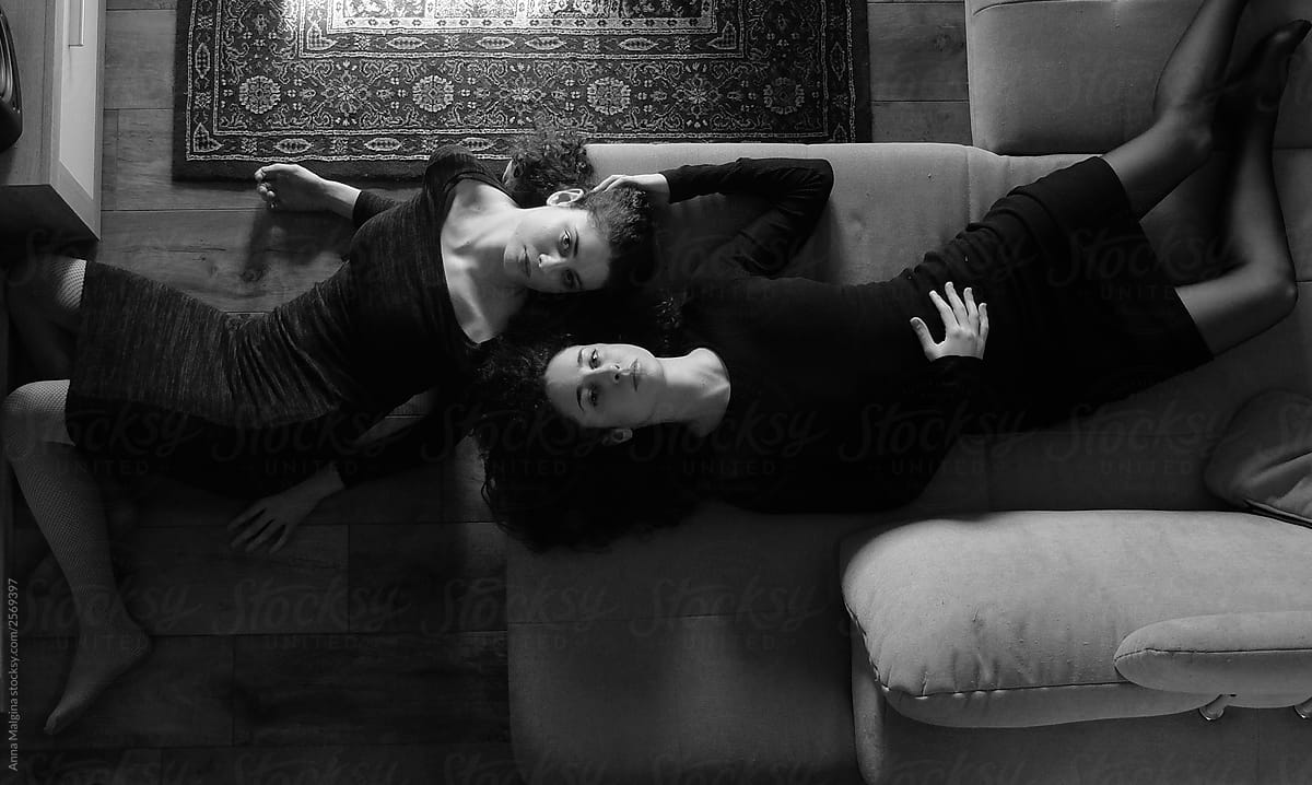 Two sisters shot from above chilling on a sofa