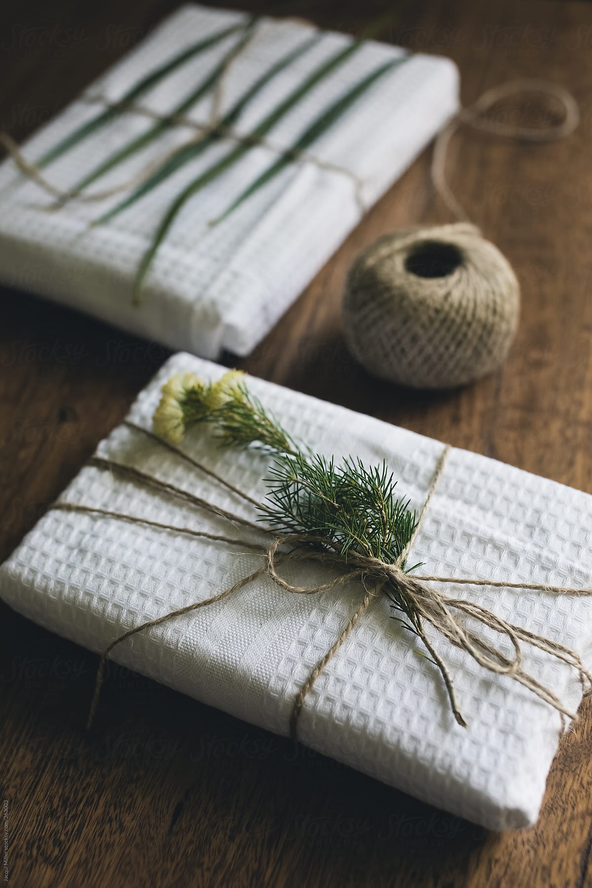 Gifts wrapped in reusable dish towel, decorated with native plants and garden twine