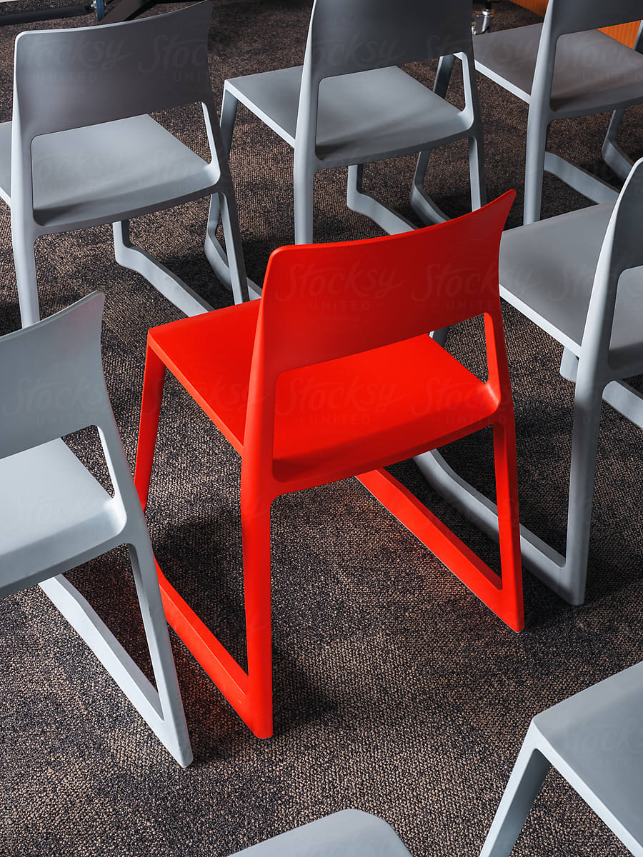 Red chair amidst gray seats