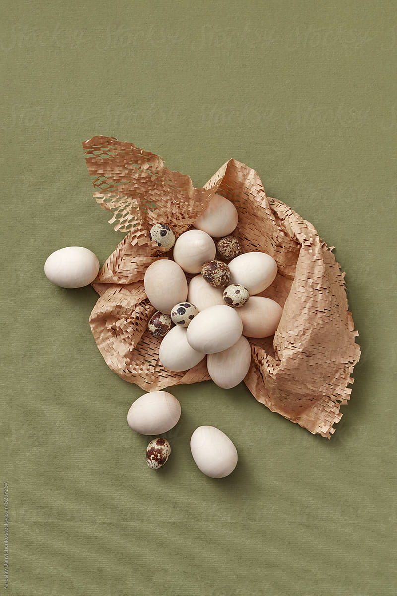 Easter wooden and quail eggs on woven paper mesh.