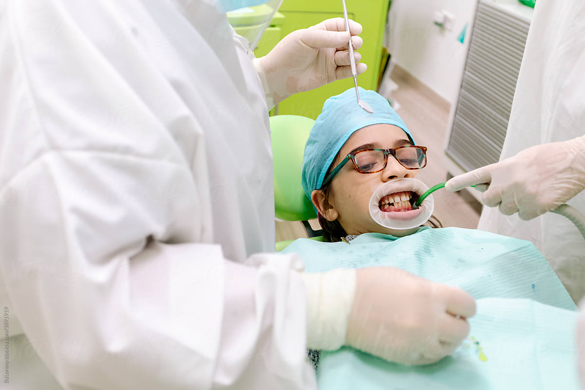 Crop dentists curing teeth of boy