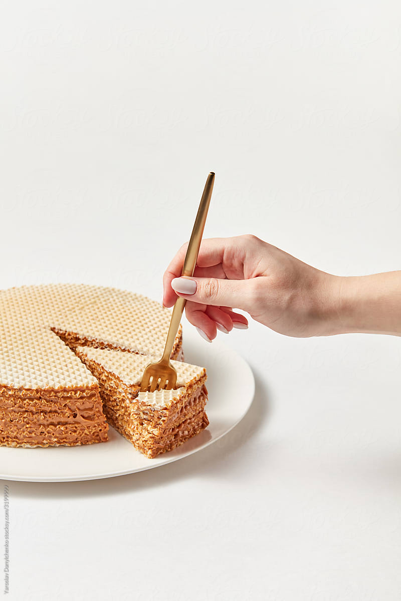 Woman's hand takes waffle cake.