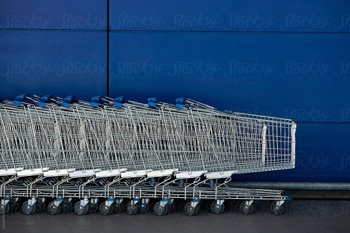 Shopping carts against a blue wall.
