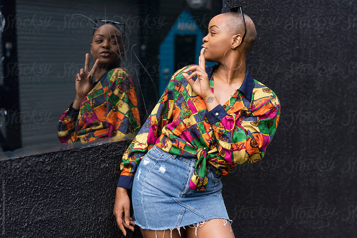 Black woman looks at herself in a mirror