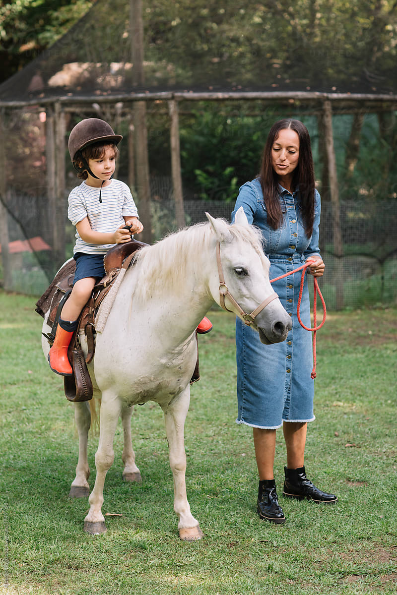 Kid Riding A Horse At Farm