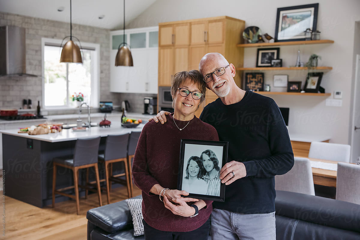 Mature couple holding old photograph.