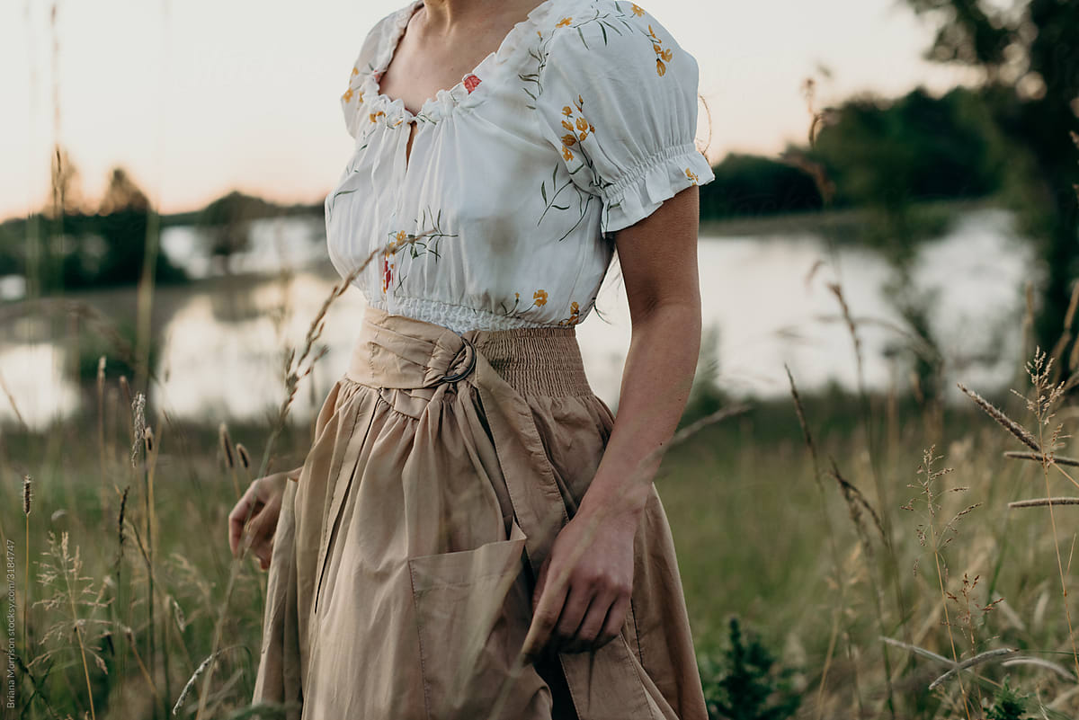Woman in field near a lake