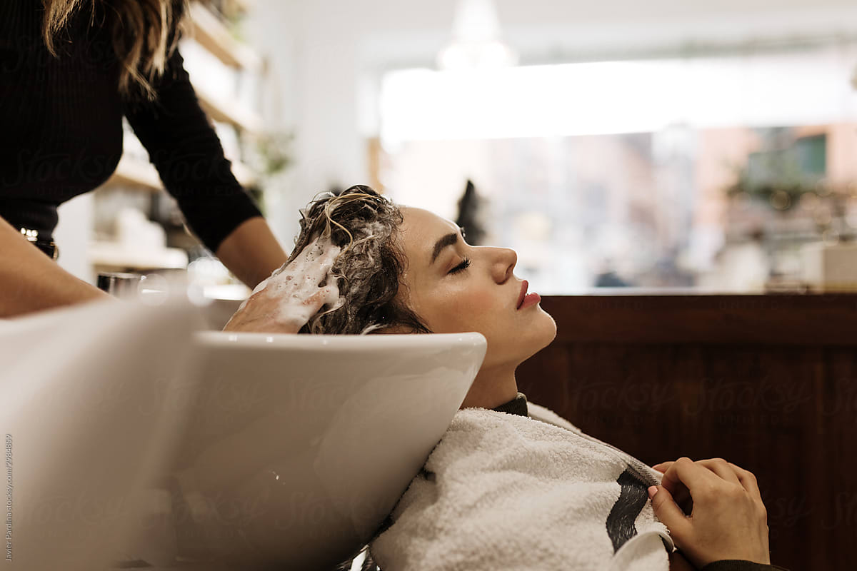 Young woman washing hair in salon