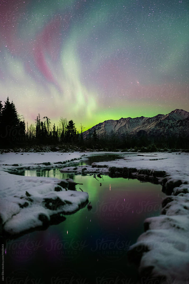 Northern Lights with Reflectio in Alaska\'s Mountains Over Thawed River