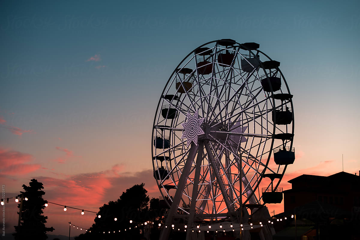 Ferris wheel at theme park during sunset