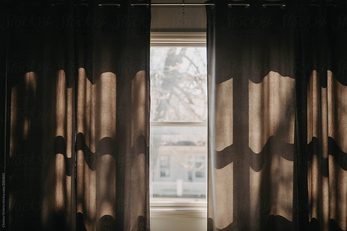 A window with curtains almost closed