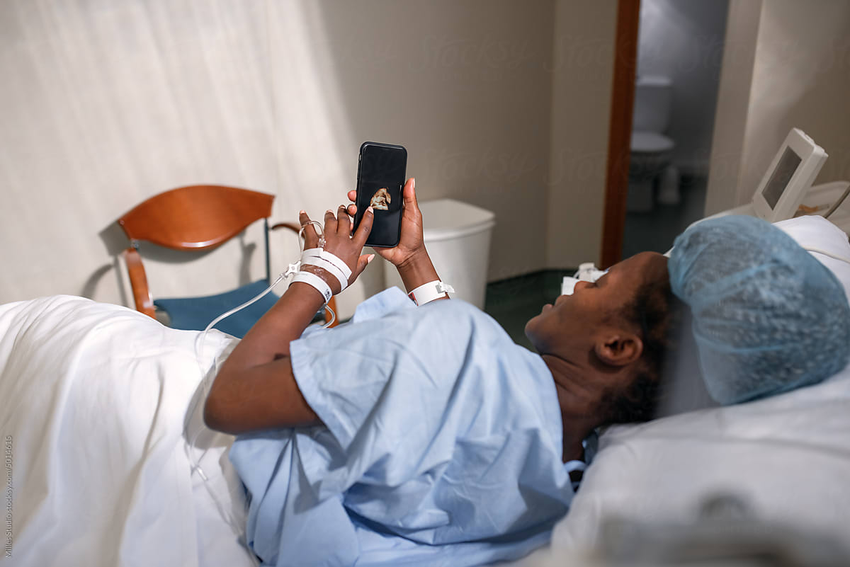 Pregnant black woman browsing sonogram on smartphone