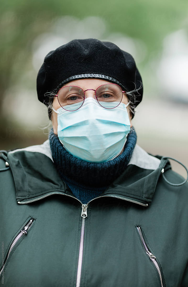 Senior woman wearing disposable mask on the street