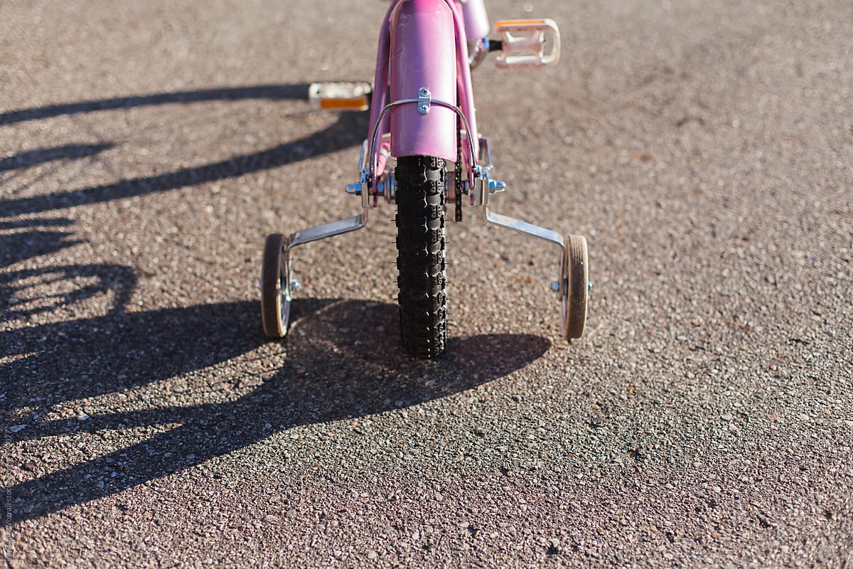 Closeup of the back of a parked child\'s bicycle with training wheels