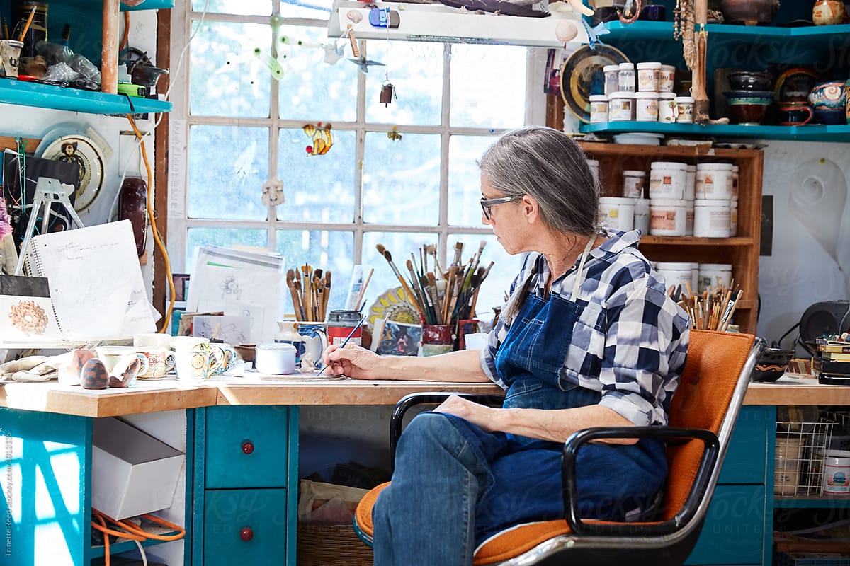 Portrait of senior woman with grey hair inside her pottery studio