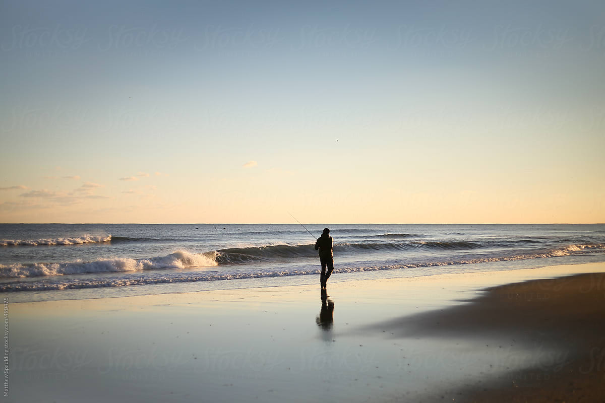 Silhouette Of Person Surf Fishing Alone On Ocean Beach With Long Rod At  Sunset by Stocksy Contributor Matthew Spaulding - Stocksy