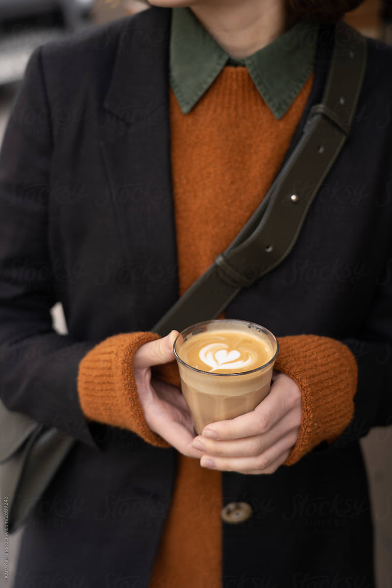 Anonymous person in coat with fragrant coffee