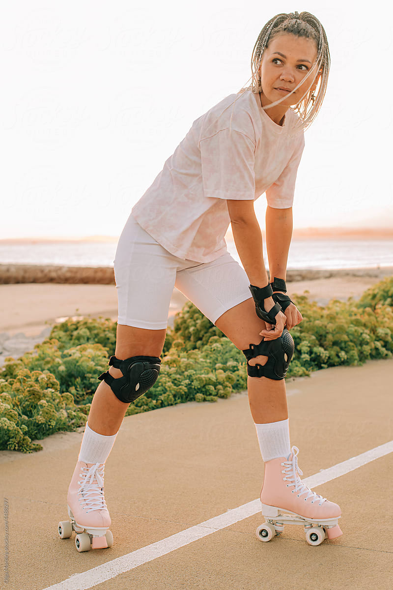Female roller skater ajusting protection