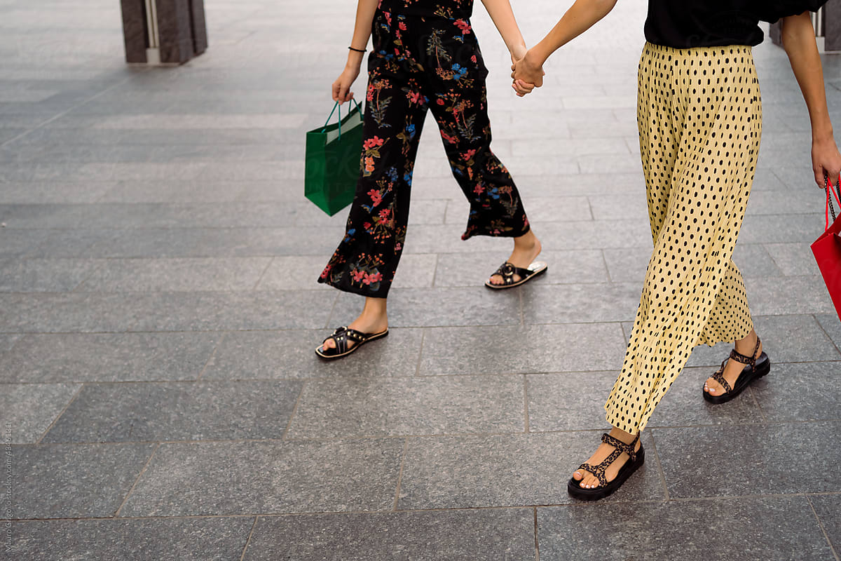 Women hand in hand after shopping