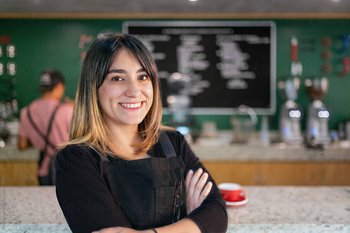 Happy business owner leaning on bar counter