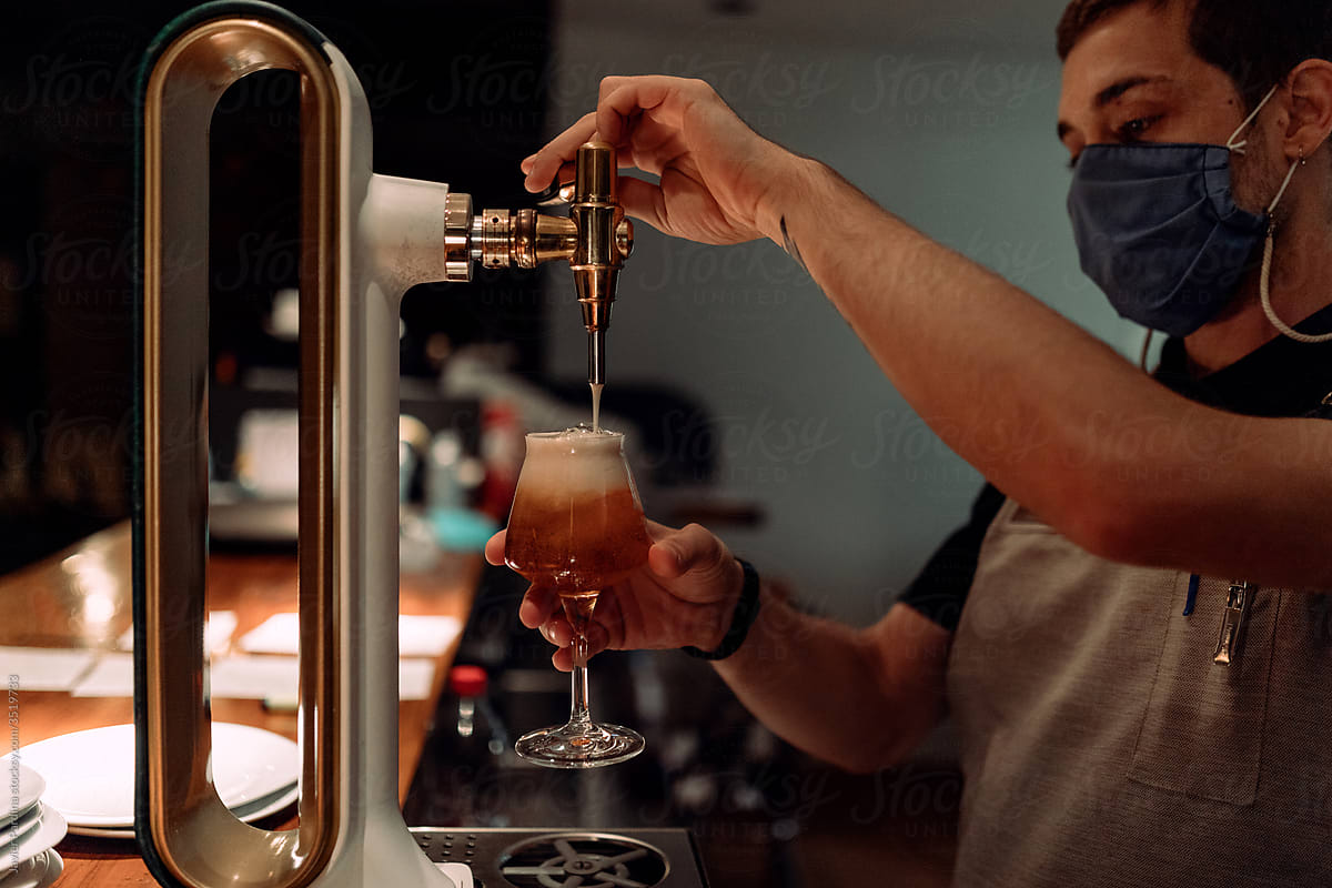 Barman hand at beer tap