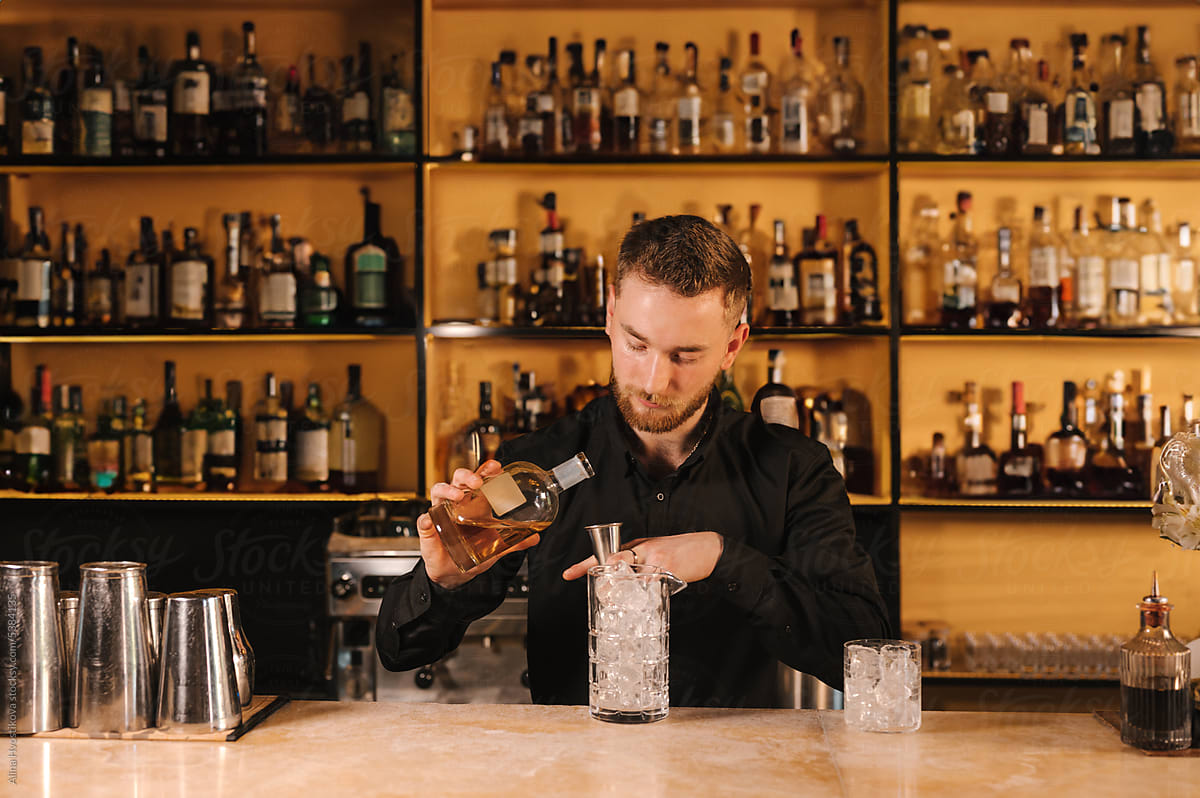 Barman pouring gin into glass