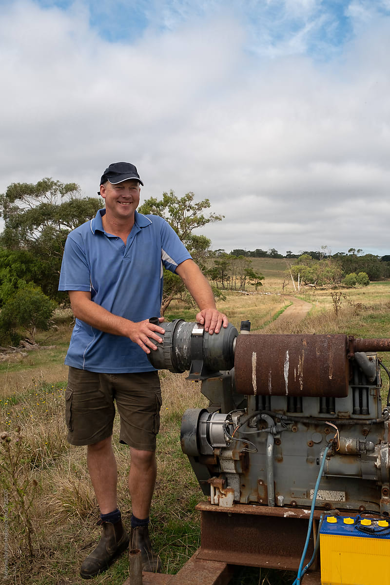 Dairy farmer standing next to water pump station on farm