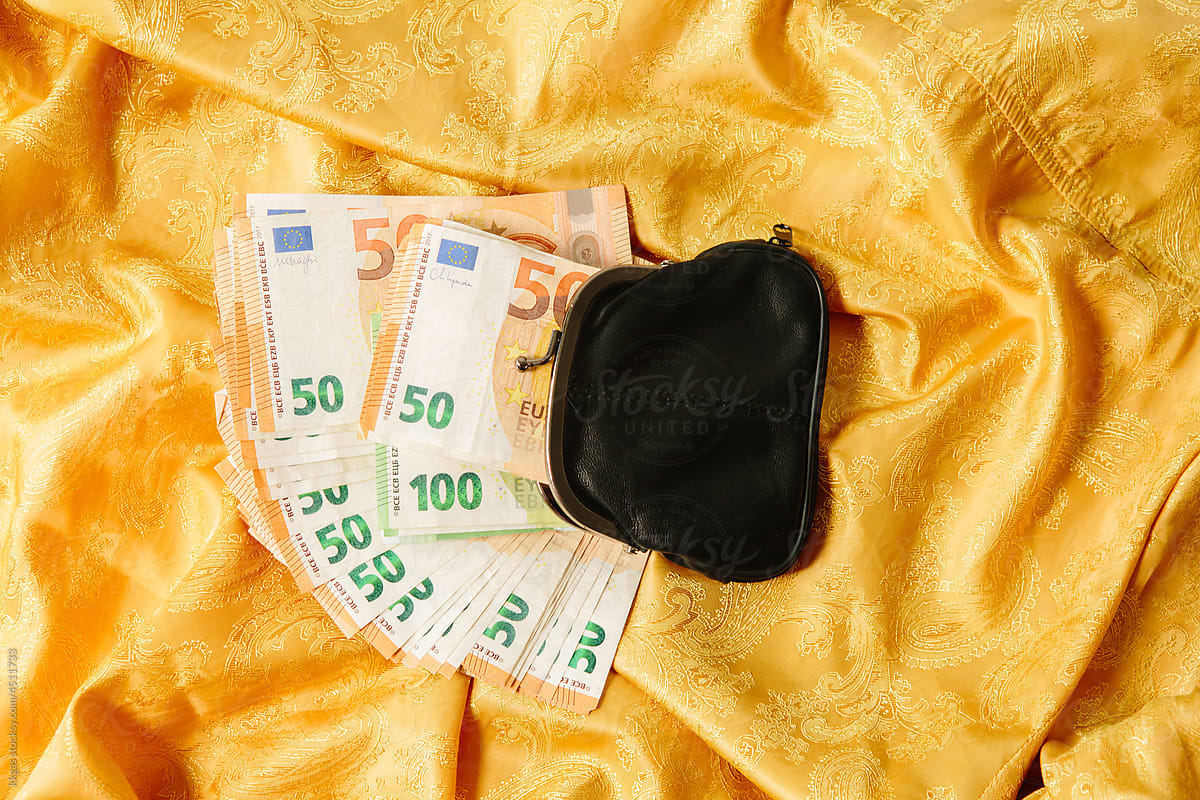 Purse and money on a gold background