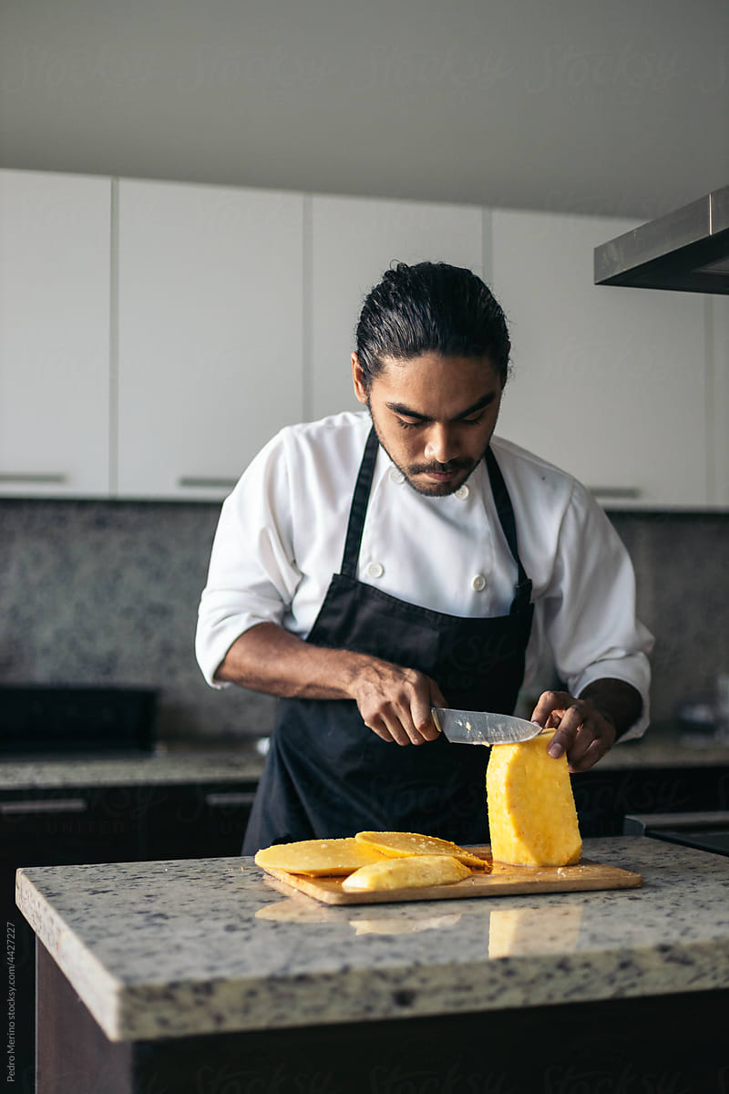 Pastry chef cutting a pineapple