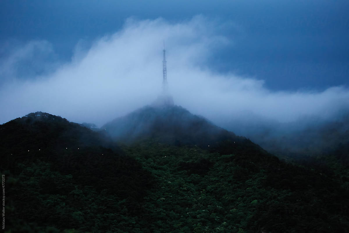 Early Morning Fog Rolling Past A Tower In Huangshan, Anhui, China.