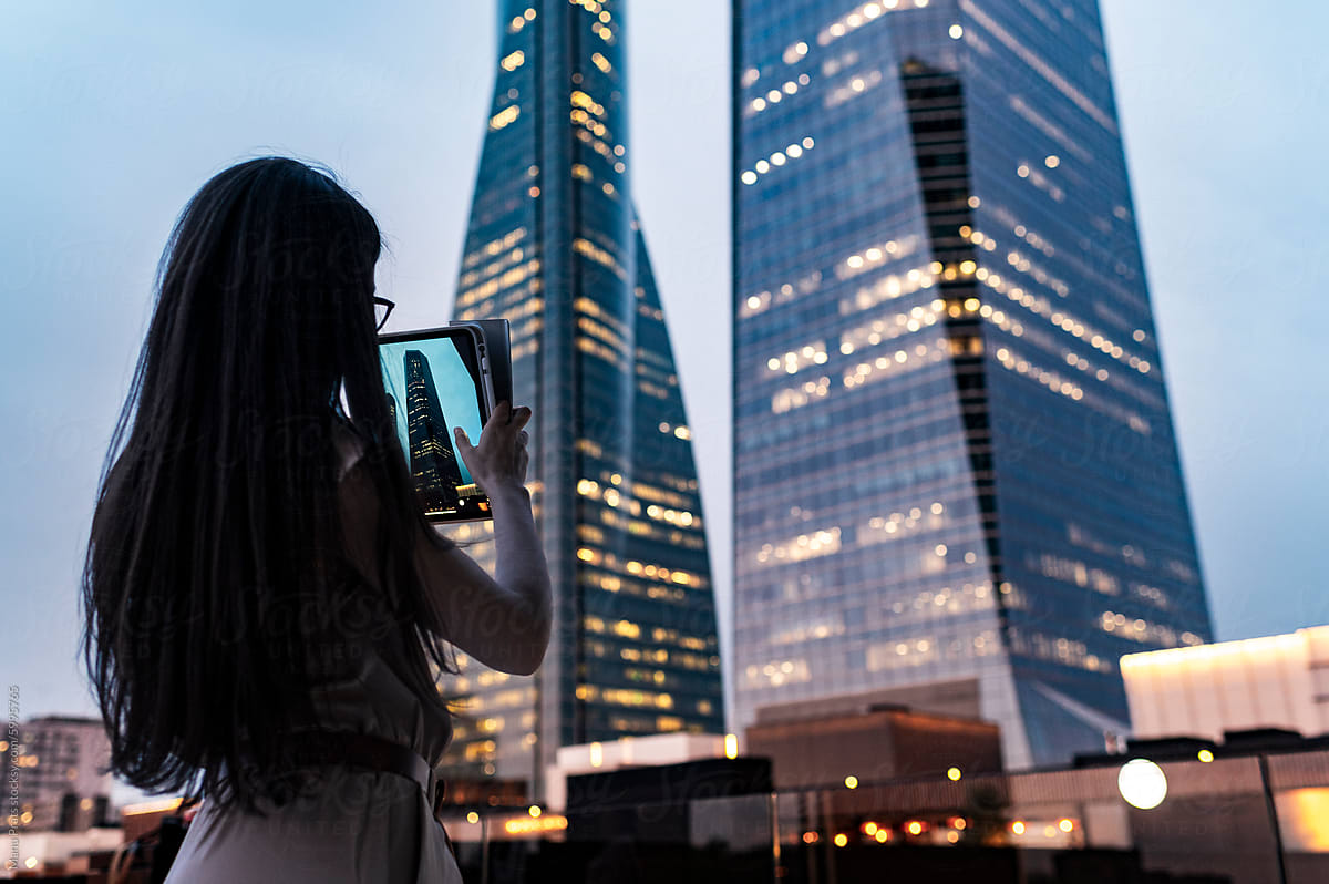 Woman urban explorer photographing architecture with digital tablet