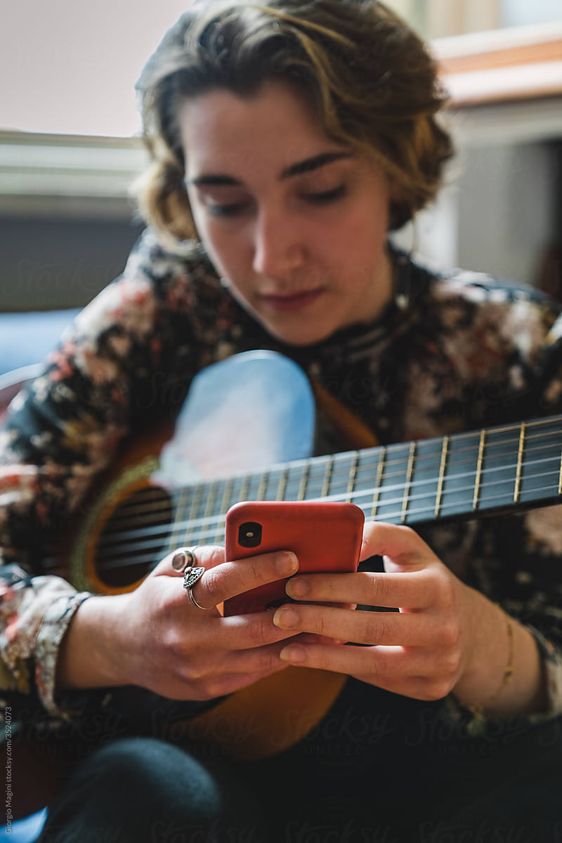 Girl with Guitar Texting on Phone