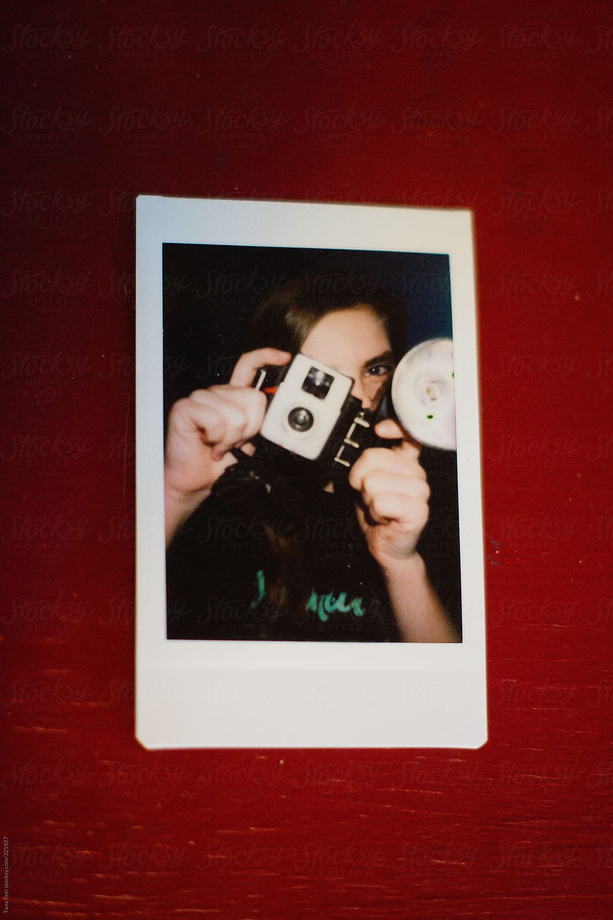 Mini polaroid image of teen taking pictures with old camera