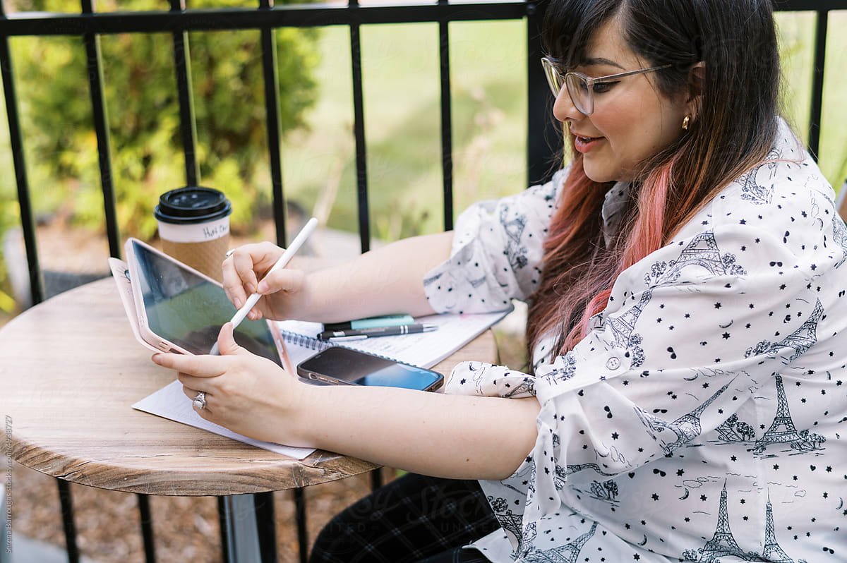 illustrator drawing on a tablet at a bistro table