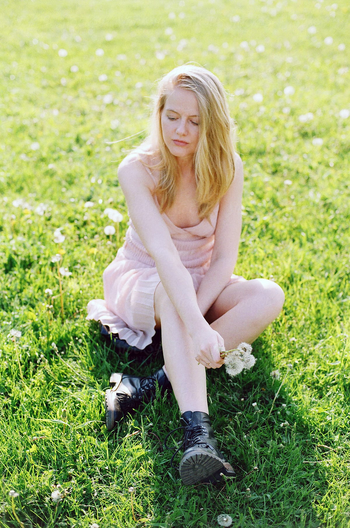 Young Blonde Woman Sitting On A Field With Dandelions Del Colaborador De Stocksy Amor 