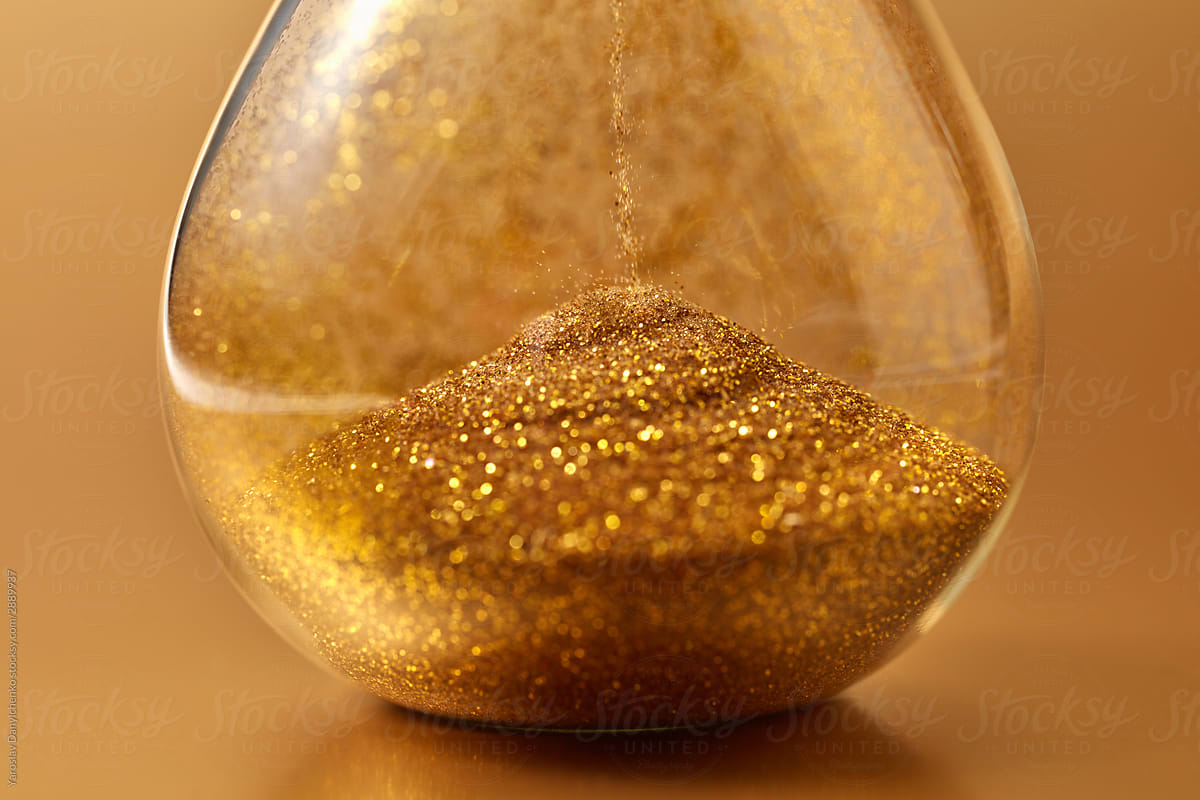 Golden sand puring in hourglass.