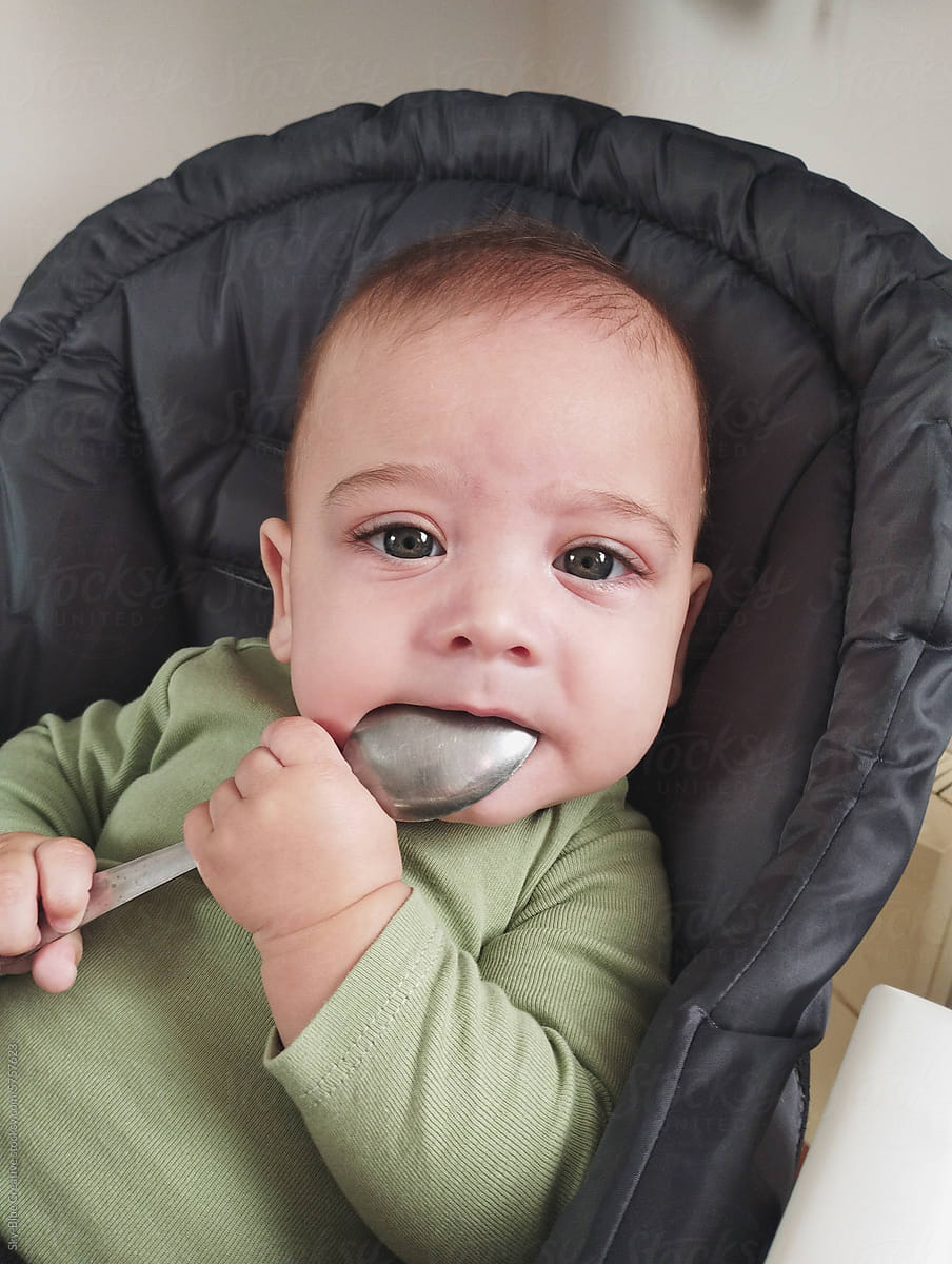 One-year-old child with a spoon in their mouth