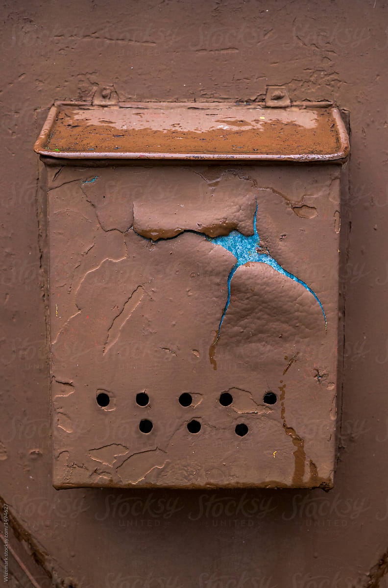 An old rusty mailbox on the wall.
