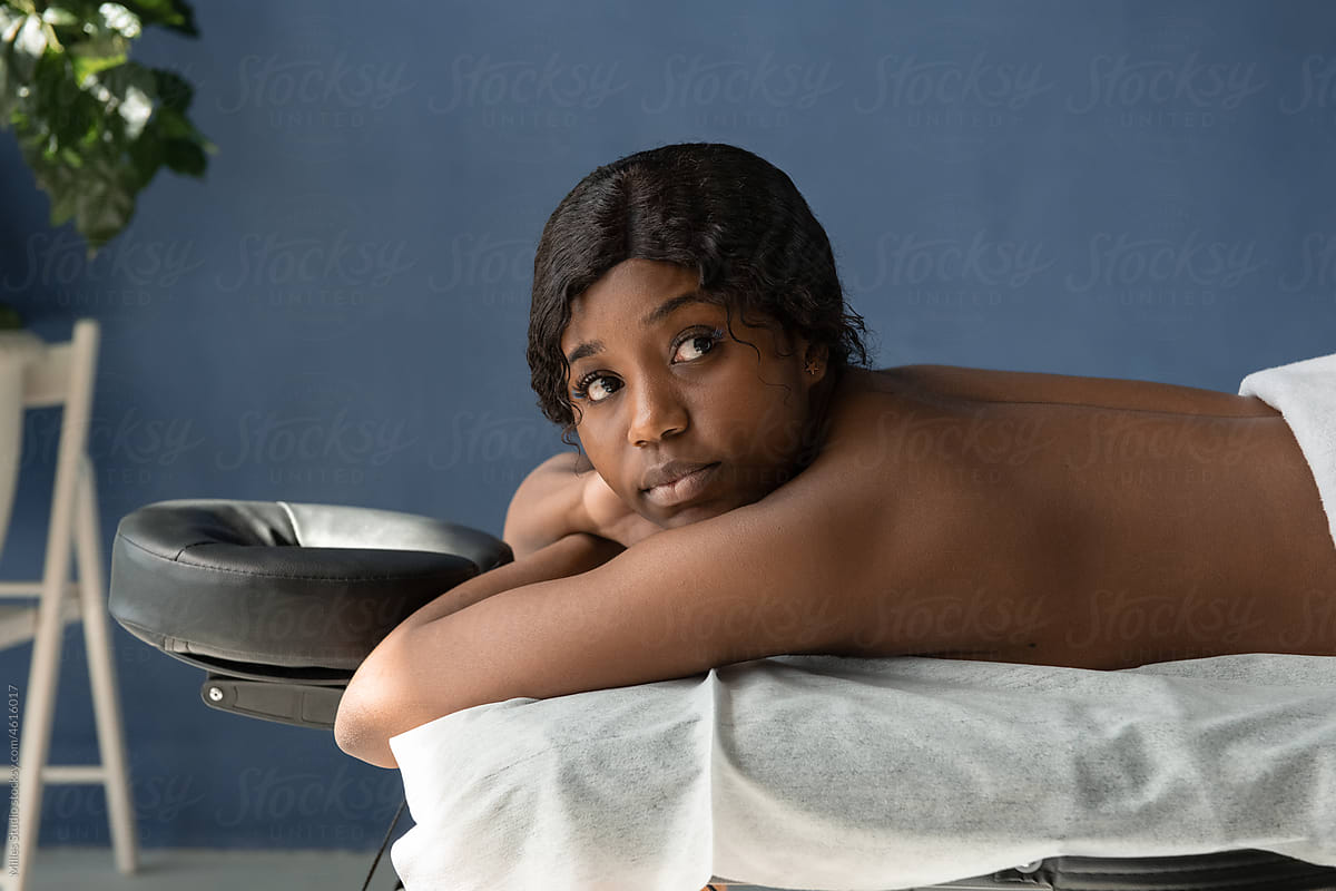 Black female customer looking away on massage table