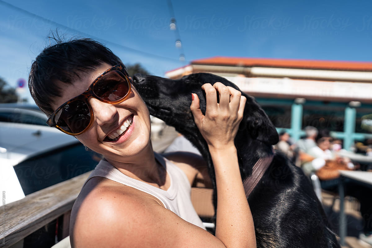 Woman Holding Black Dog in Arms