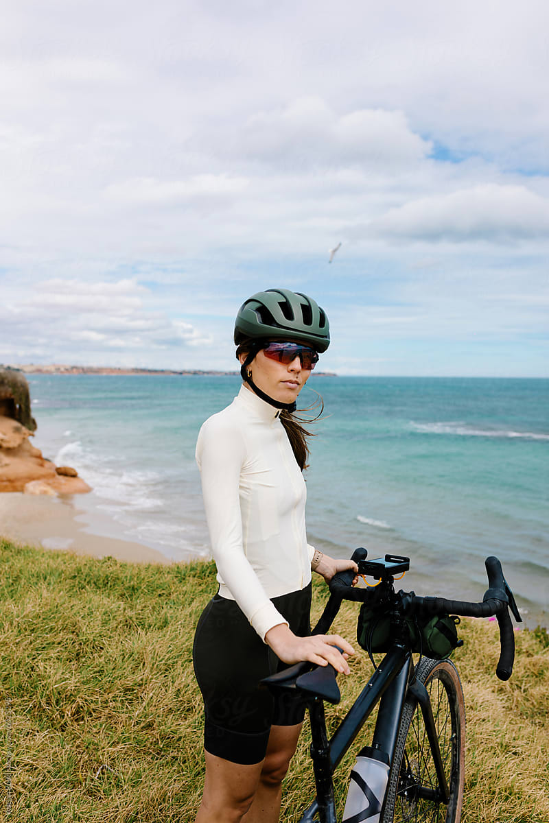 Portrait of woman dressed in a cycling jersey next to her gravel bike