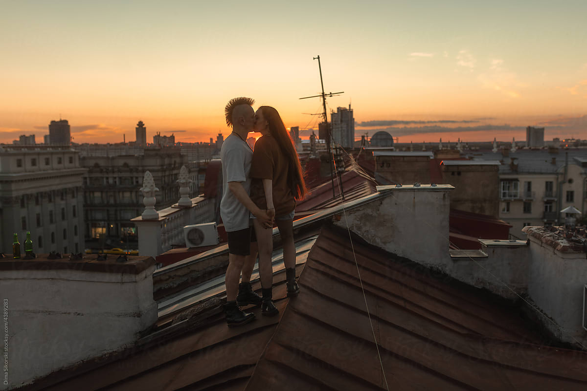 couple in love kissing on the roof after sunset