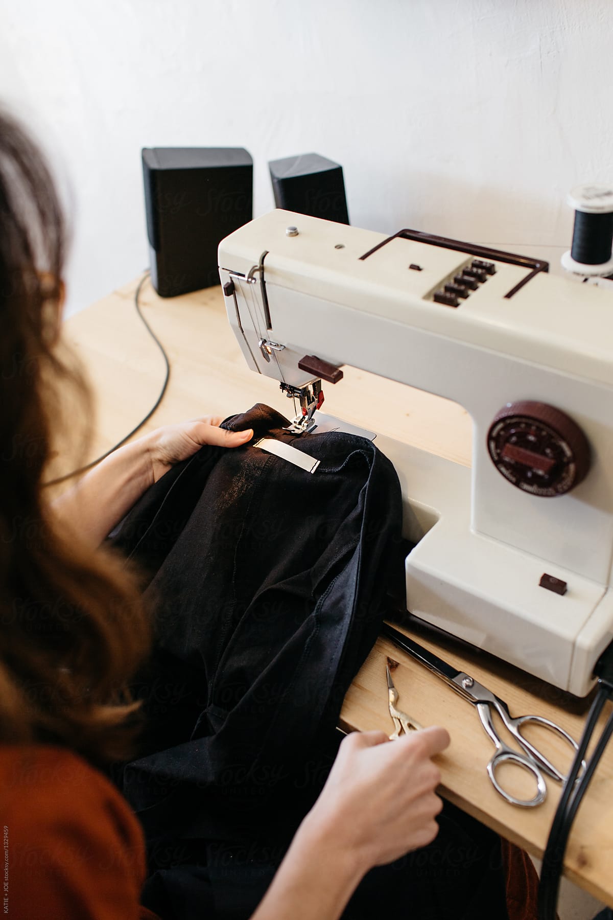 Woman sewing a label on a black blouse with a sew machine