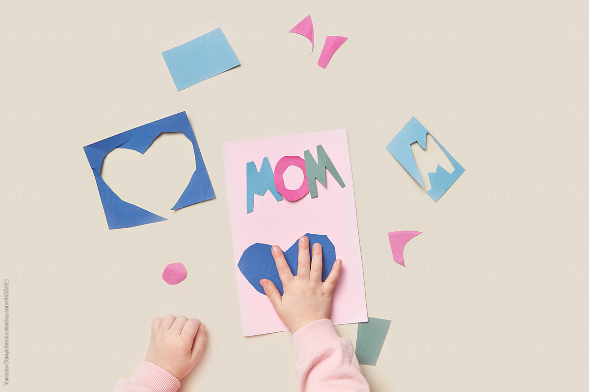 Child making greeting card from colorful paper