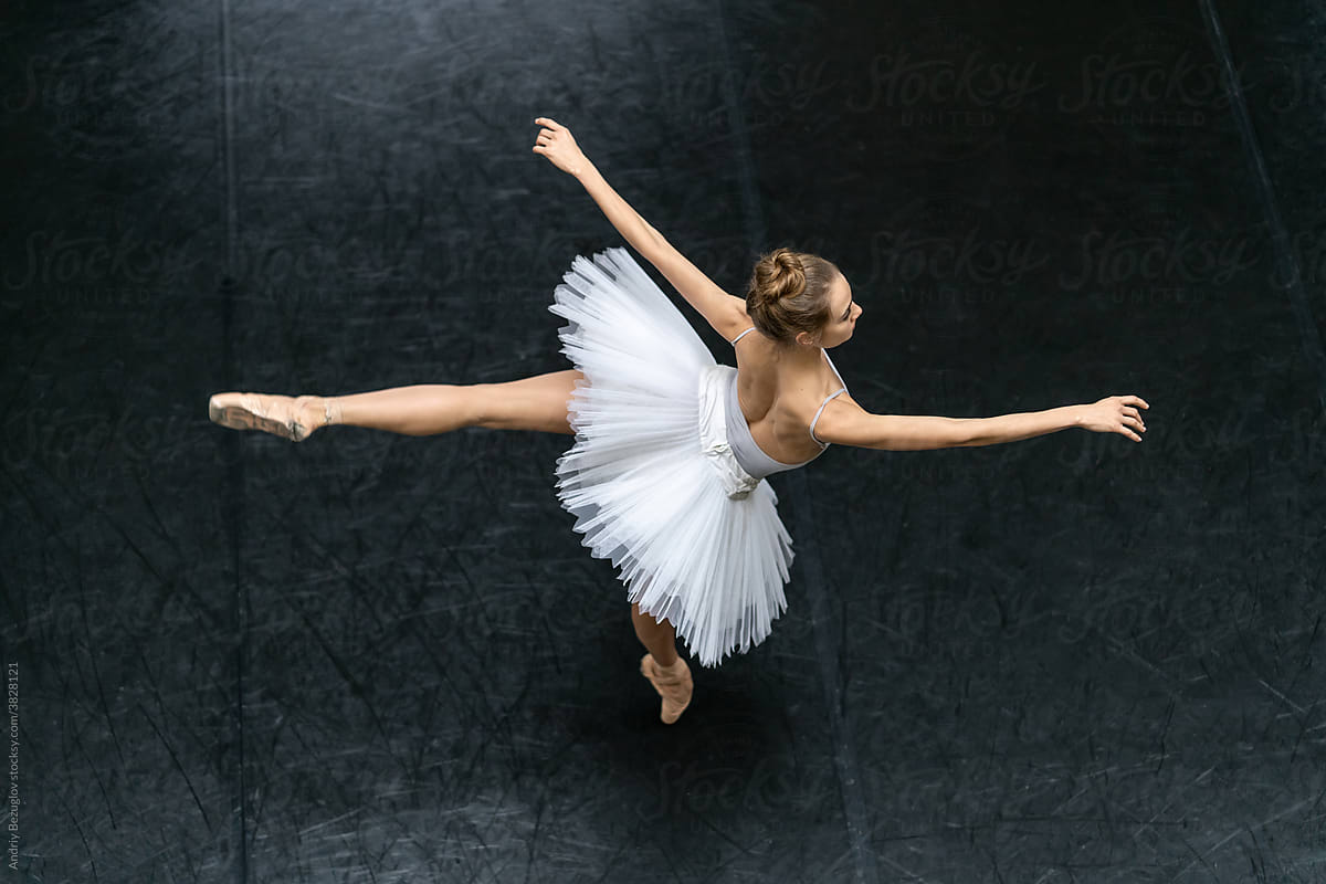 Female ballet dancer posing inside dance hall