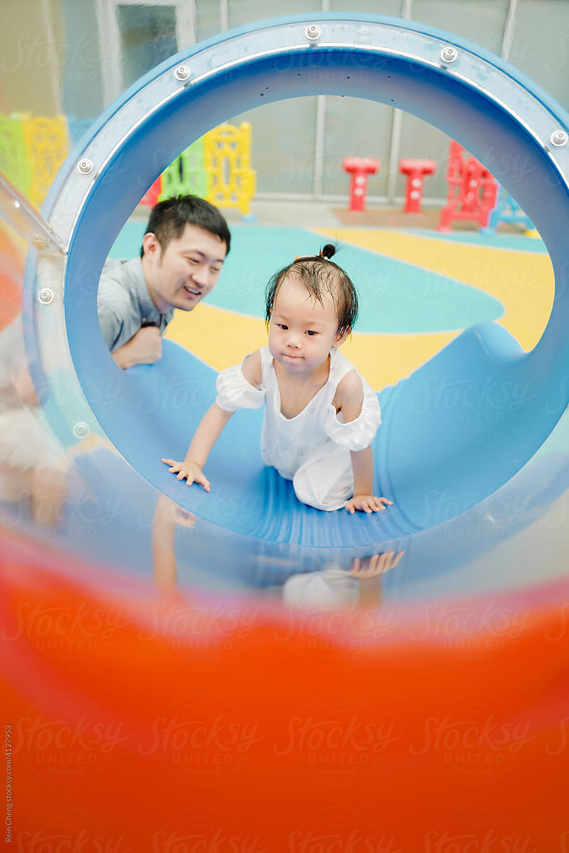 Asian father and daughter play slide
